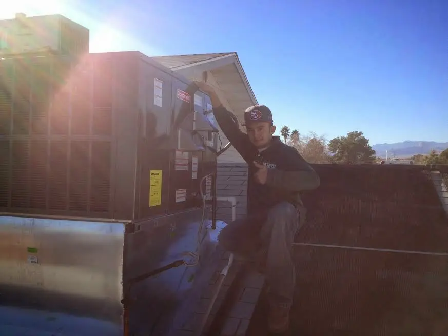 HVAC technician performing Heat Pump Repair on a rooftop unit in Walnut Ridge