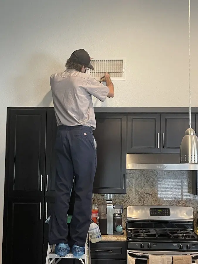 Technician inspecting an air vent during HVAC service in Walnut Ridge
